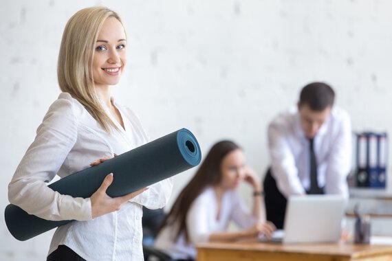 Une employée tenant un tapis de yoga