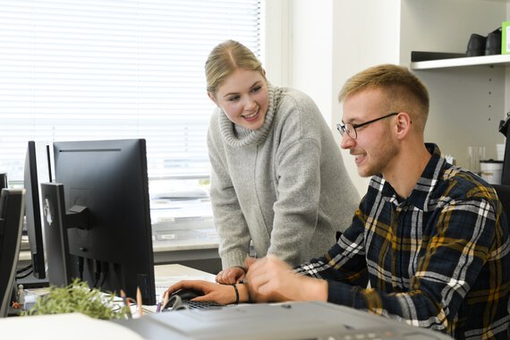 Photo of two Böllhoff apprentices in front of a screen