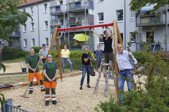 A group of people set up a new swing in a playground.