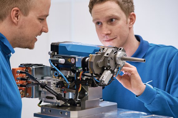 Two employees standing on an assembly device from Böllhoff