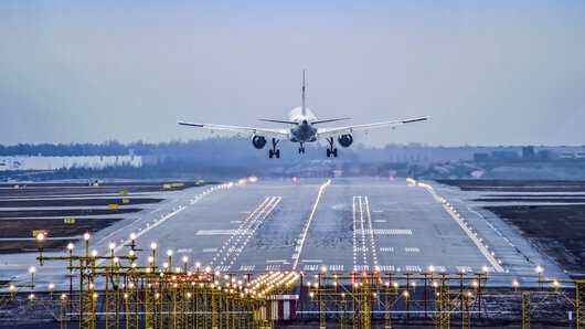 夕暮れ時に離陸する航空機のイメージ