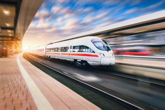 Zug fährt durch einen Bahnhof.