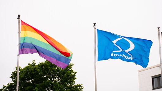 Le drapeau du groupe Böllhoff à côté d'un drapeau arc-en-ciel