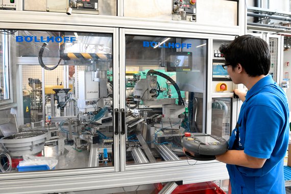 Photo of a Böllhoff apprentice in front of automated equipment