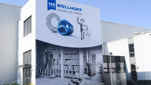 Der Schraubenbankier auf einem Jubiläumsbanner am Böllhoff Hauptsitz in Bielefeld