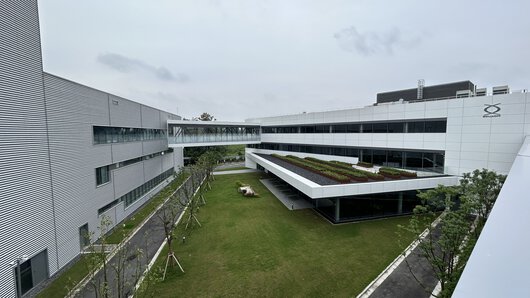 Nová budova společnosti Böllhoff v čínském Wu-si s „ozeleněnou“ podnikovou restaurací – a kancelářskými prostory a výrobními halami za ní.