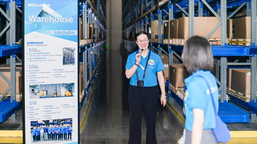 Una guida femminile mostra l’azienda a persone interessate al family day del gruppo Böllhoff a Wuxi, in Cina