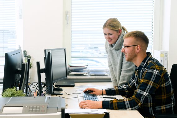 Two trainees in front of a screen