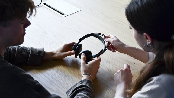 Blick über die Schulter von zwei Böllhoff Azubis, die am Projekt Energie-Scouts 2024 teilnehmen, auf ein PC-Headset in ihren Händen