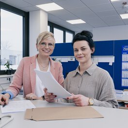 Zwei Böllhoff Mitarbeiterinnen stehen gemeinsam am Schreibtisch