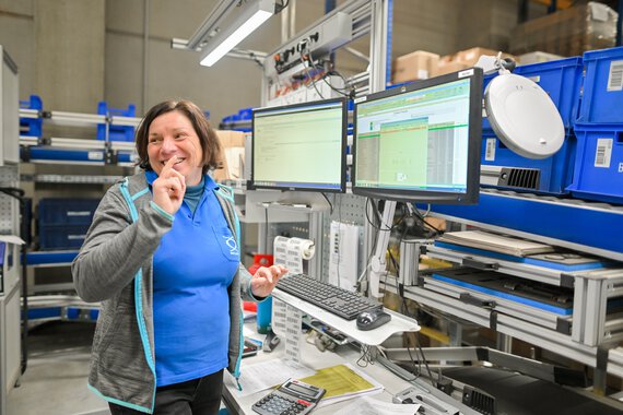 eine Böllhoff Mitarbeiterin bei der Arbeit am PC im Wareneingang am Logistikstandort Oelsnitz