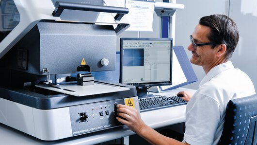 Zamestnanec laboratória Böllhoff kontroluje chemické zloženie materiálu v optickom emisnom spektrometri.