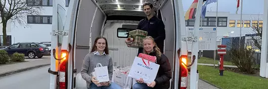 The donated gifts are handed over to employees of the German Red Cross by a Böllhoff employee.