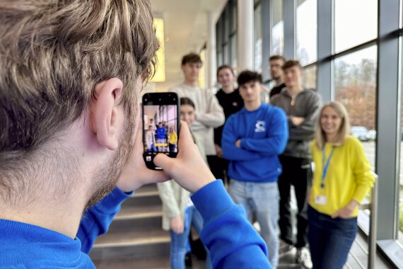 Das Instagram-Team von Böllhoff macht ein Foto mit dem Smartphone.