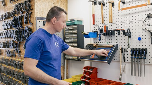 Ein Böllhoff Mitarbeiter am Produktionsstandort Sonnewalde an einem ergonomischen Arbeitsplatz im Fertigungsbereich