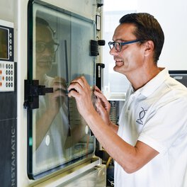 Funcionários do laboratório de testes certificado que realizam um teste com pulverização de sal