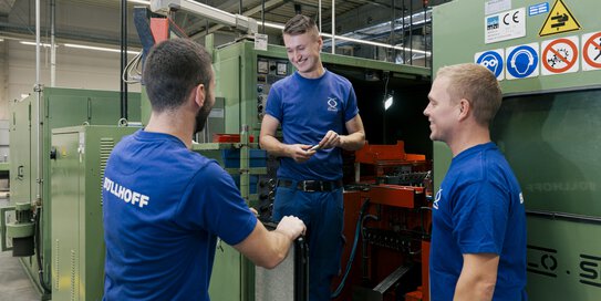 Drei Böllhoff Kollegen stehen an einem Produktionsgerät