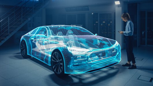Inżynierka motoryzacji używa tabletu cyfrowego z funkcją rzeczywistości rozszerzonej do opracowania i udoskonalania projektu samochodu.