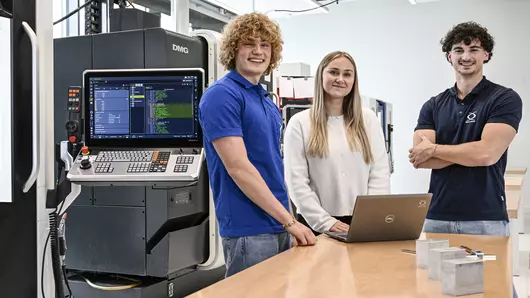 Three Böllhoff apprentices stand at a laptop in the new Bildungscampus Böllhoff in Bielefeld.