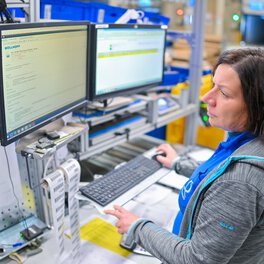 Eine Mitarbeiterin im Wareneingang ließt Mails auf einem Bildschirm