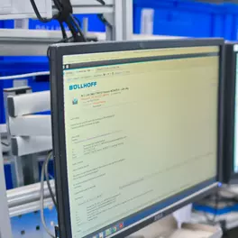 Eine Mitarbeiterin im Wareneingang ließt Mails auf einem Bildschirm