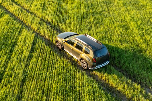 Zdjęcie jadącego w polu Renault Duster