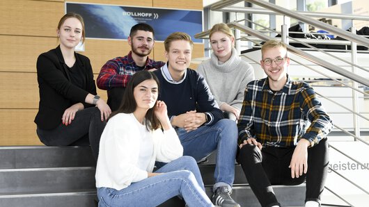 Eine Gruppe von Böllhoff Auszubildenden sitzen auf einer Treppe