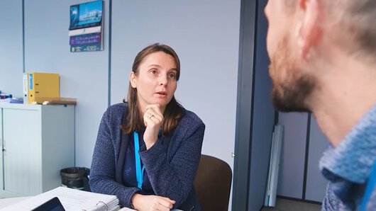 Eine Mitarbeiterin vom Böllhoff Standort in La Ravoire, Frankreich, spricht im Büro mit einem Kollegen.