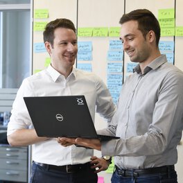 Photo of two Böllhoff employees in front of a laptop