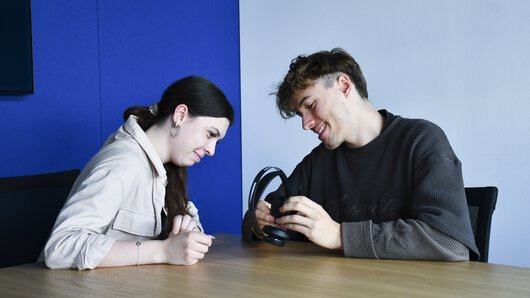 Zwei Böllhoff Azubis, die am Projekt Energie-Scouts 2024 teilnehmen, mit einem PC-Headset in der Hand