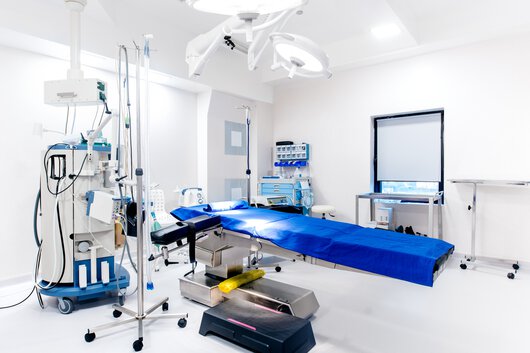 Sala operatoria vuota, dettagli di dispositivi salvavita, tavolo operatorio, lampade e strumentazione medica.