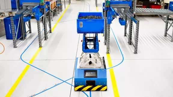 An automated guided vehicle (AGV) transports parts in the assembly production