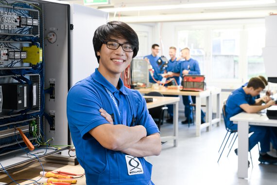 Photo of a Böllhoff apprentice in front of a fuse box