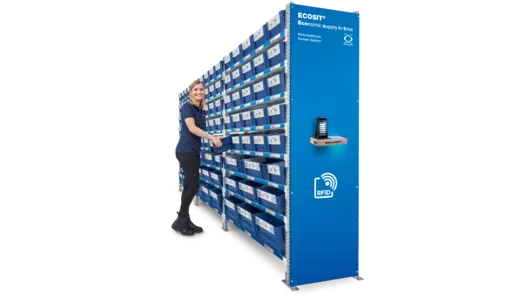 A woman standing at the control centre of an ECOSIT® system is reaching for a Kanban ECOBIN.
