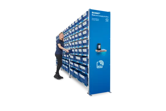 Žena stojaca v riadiacom stredisku systému ECOSIT® siaha po prepravke Kanban ECOBIN.
